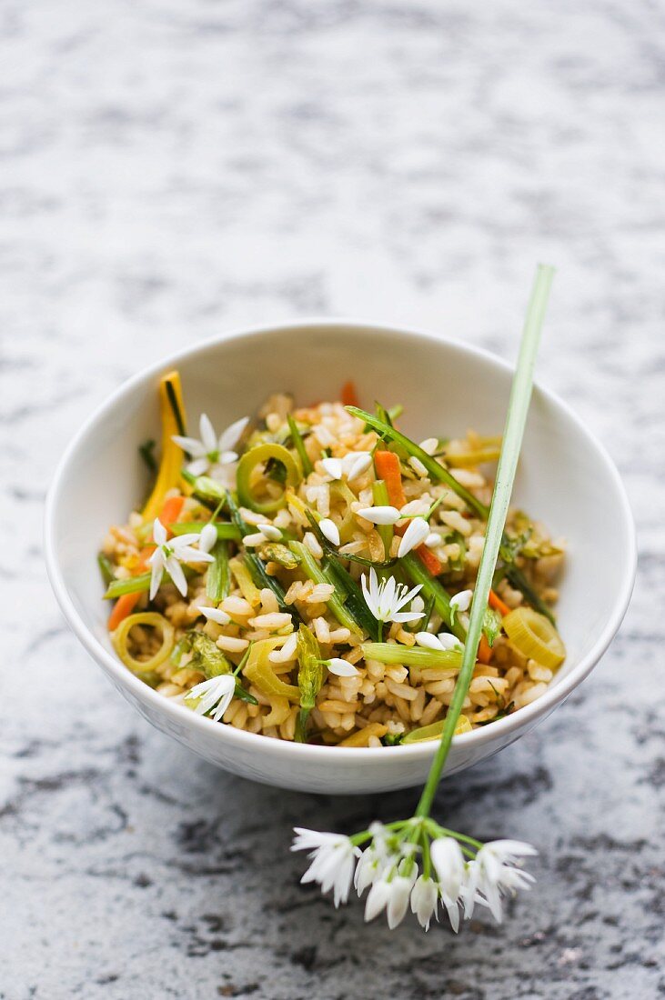 Fried rice with vegetables and ramson flowers