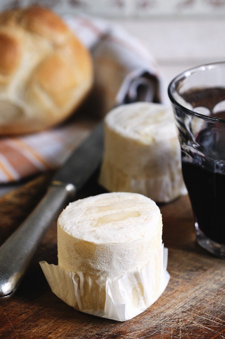 An arrangement of goat's cheese, a glass of red wine and bread