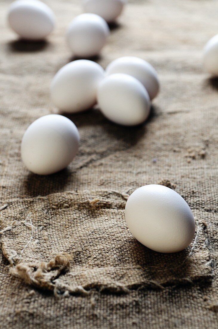 Mehrere weiße Eier auf Jute