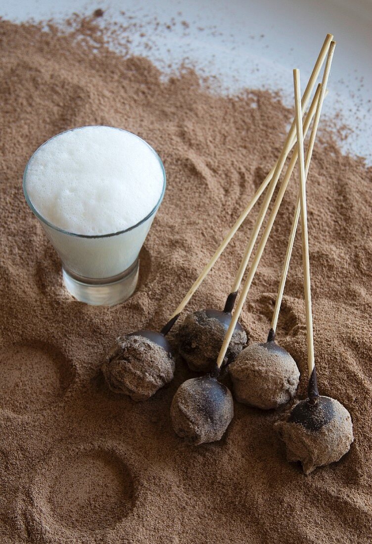 Chocolate truffles on sticks, with a glass of hot milk