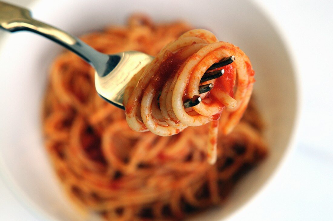 Spaghetti mit Tomatensauce auf Teller und Gabel