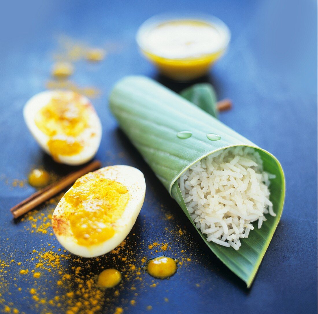 A hard-boiled egg with coconut sauce and rice in a banana leaf (Sri Lanka)