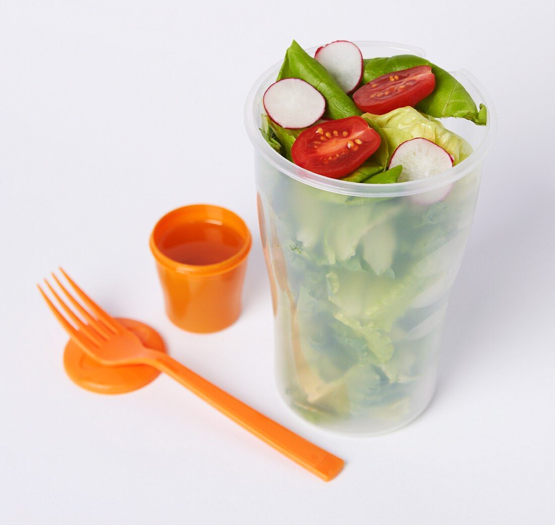 Salad in a To-Go Container with a Small Container of Dressing and a Plastic Fork