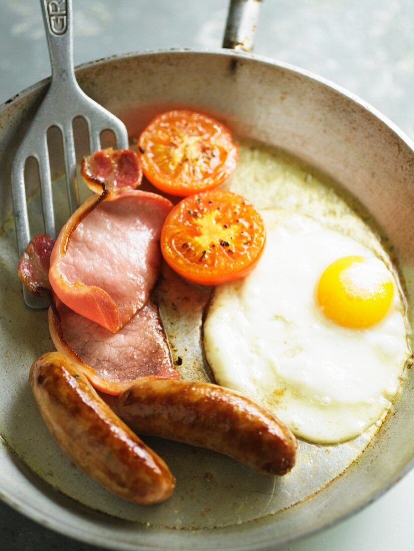 Englisches Frühstück mit Spiegelei, Würstchen, Bacon, Tomaten