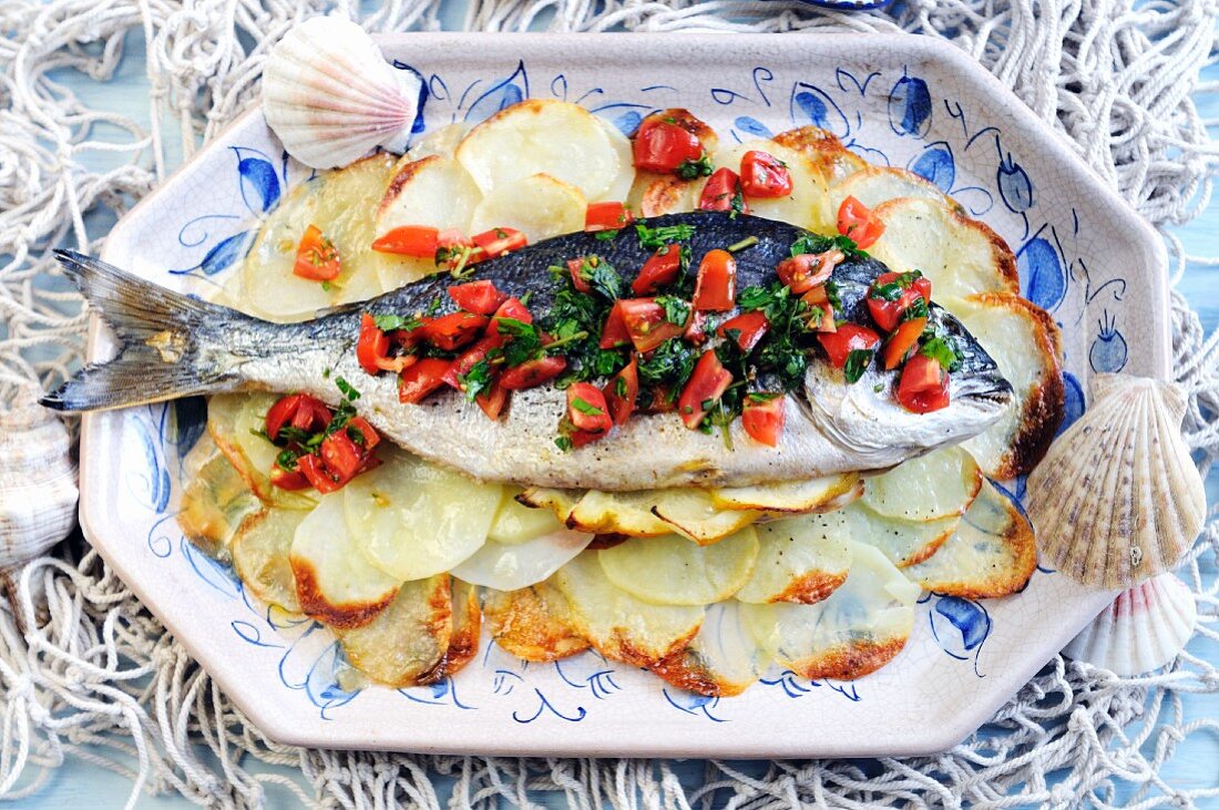 Gebratene Meerbrasse mit Tomatendressing auf Kartoffelscheiben