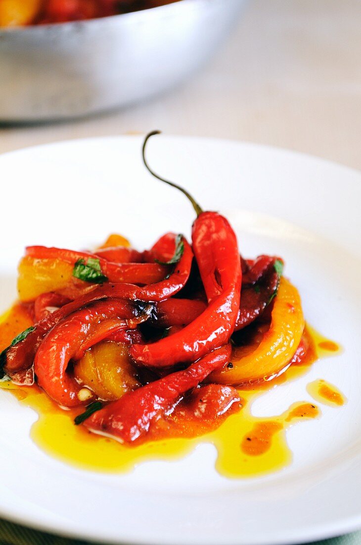 A plate of pan cooked sweet red and yellow peppers with fresh chilies and sun dried tomatoes