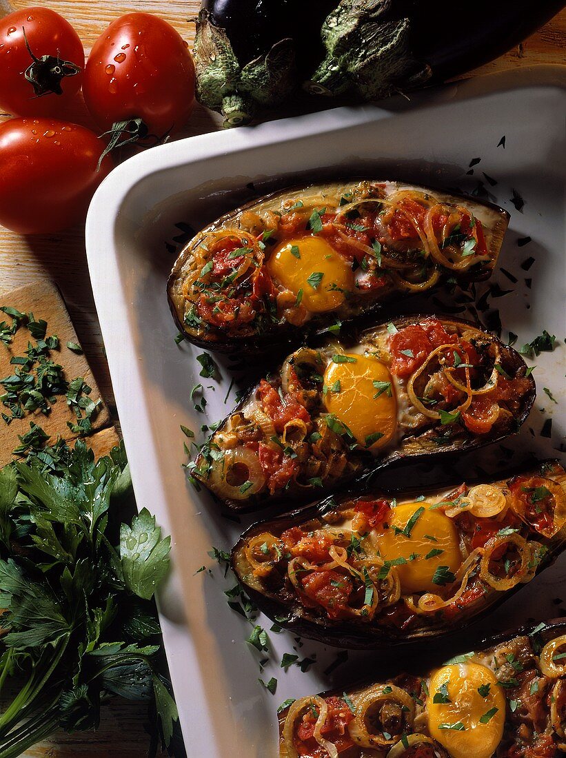 Eggs on aubergines with tomato & onion topping in baking dish