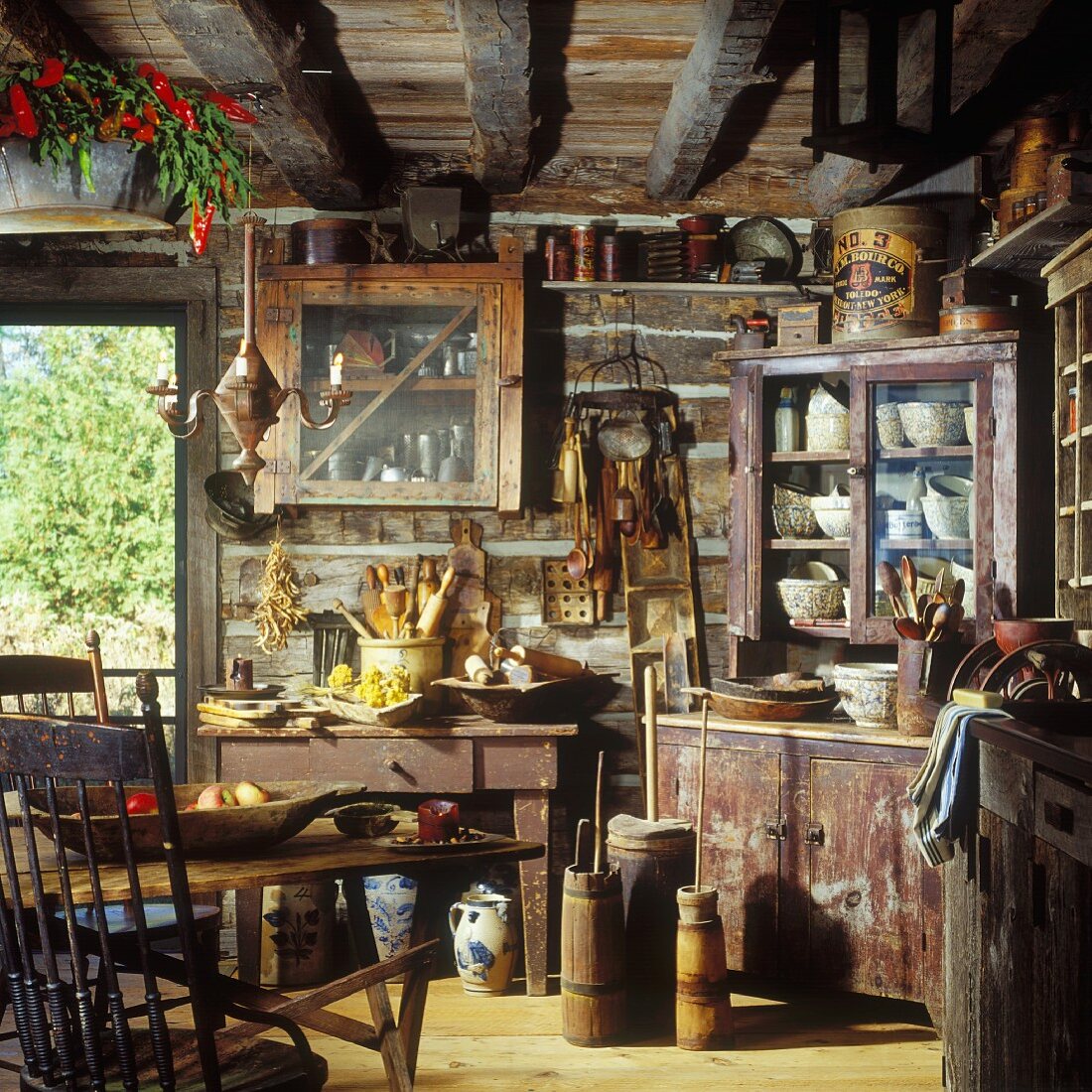 Rustikale Blockhausküche mit Balkendecke und antiken Küchenutensilien