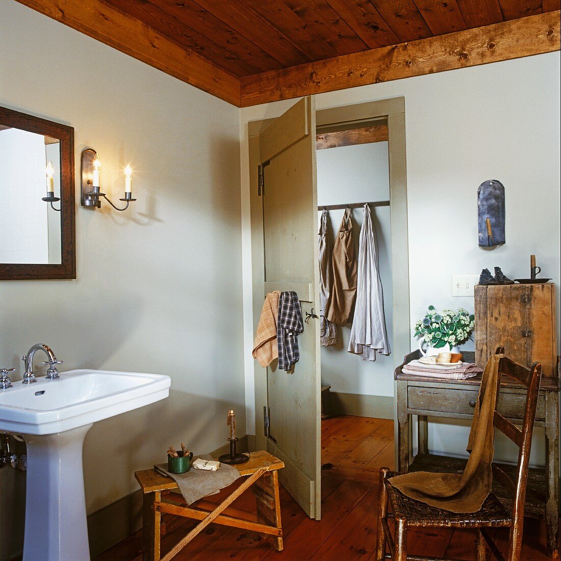 Einfaches Badezimmer mit einem Standwaschbecken und antiken Möbeln