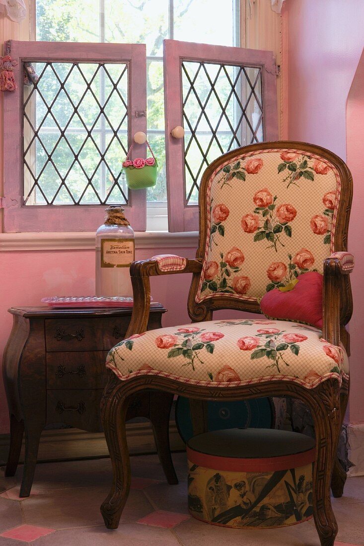 Armchair with rose-patterned upholstery in pink room