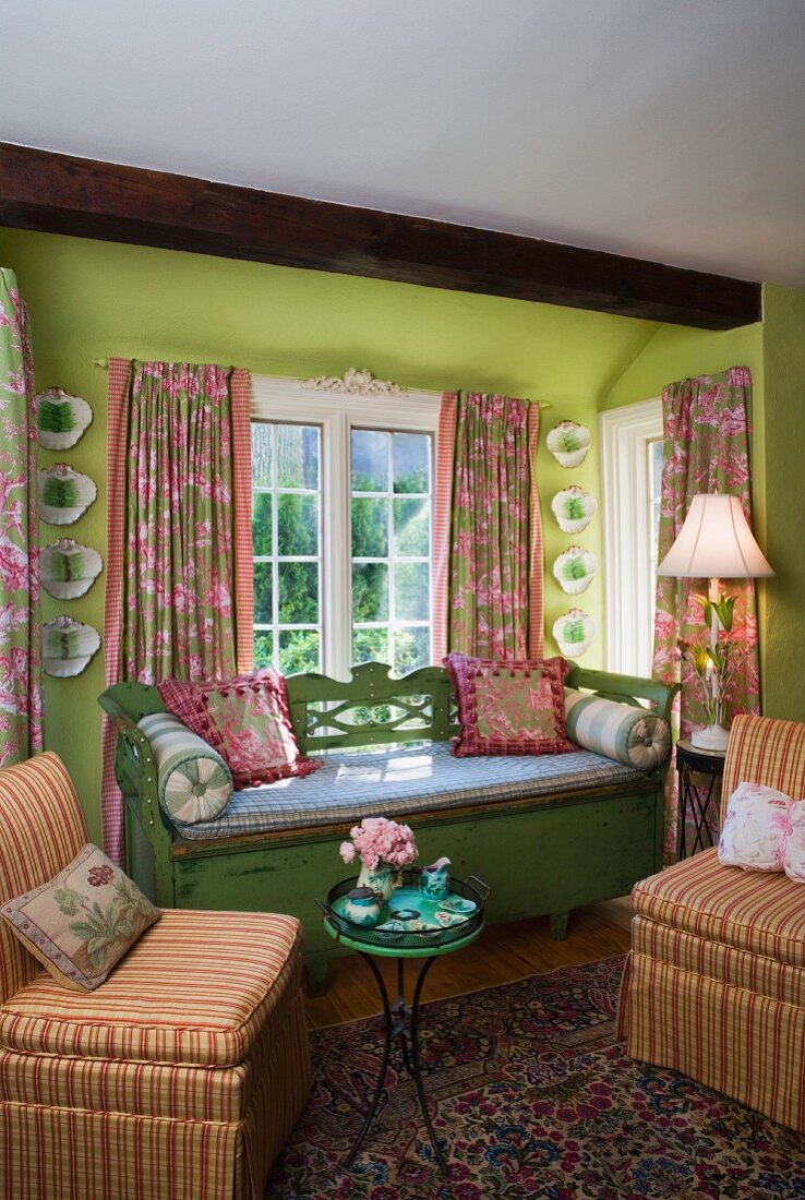 Quiet bay window with upholstered, vintage bench and round tray table