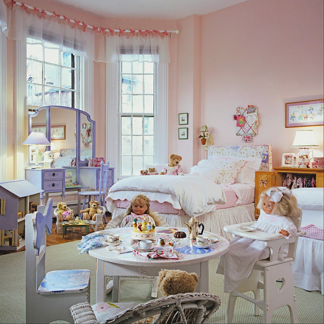 Child's bedroom in pink and light blue with ornate bed and children's furniture with dolls and soft toys