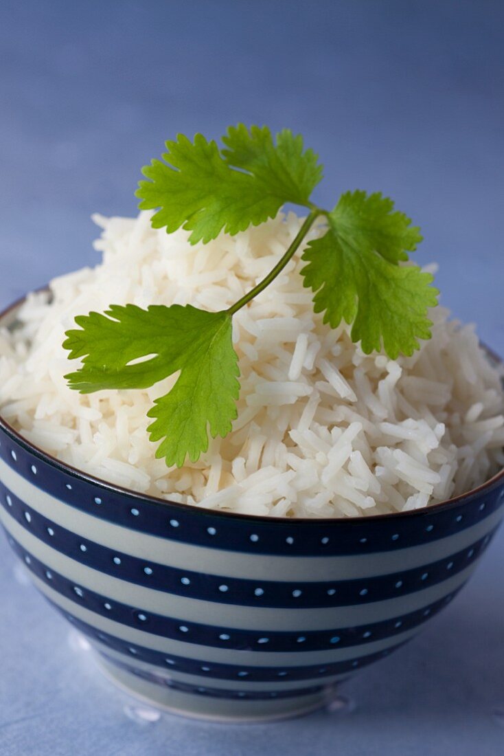 A bowl of cooked rice garnish with coriander