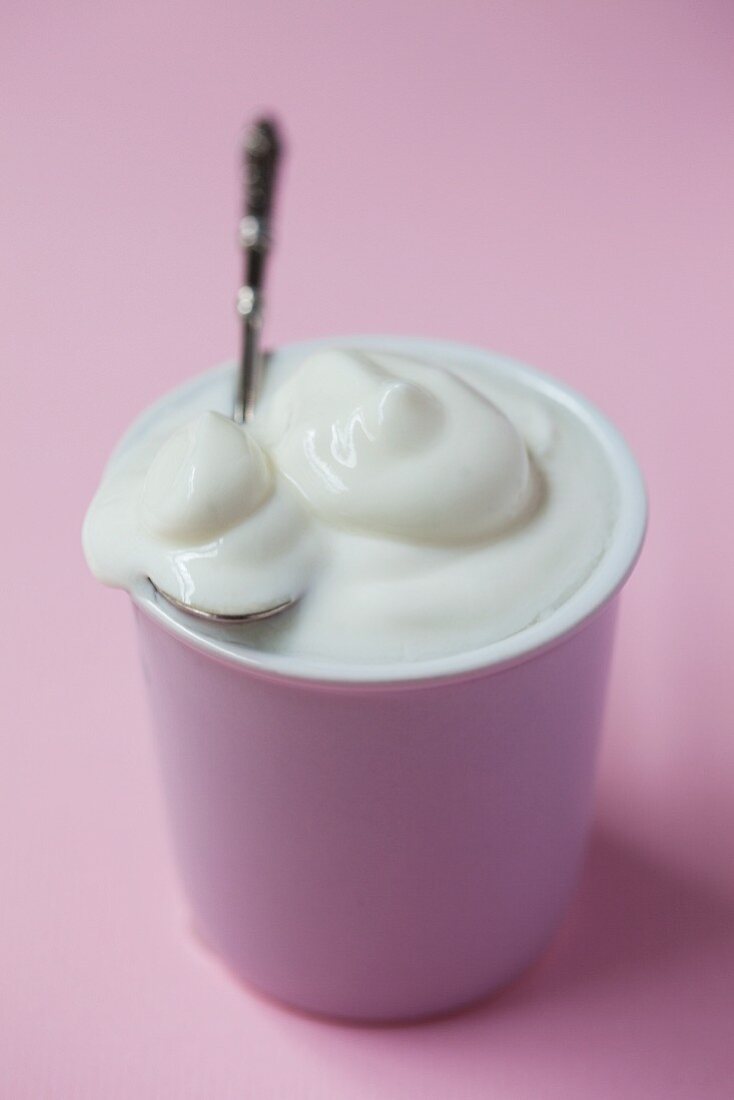 A bowl of natural yogurt with a spoon