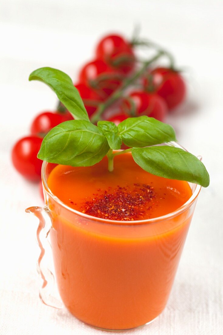 Tomato soup with basil in a glass cup