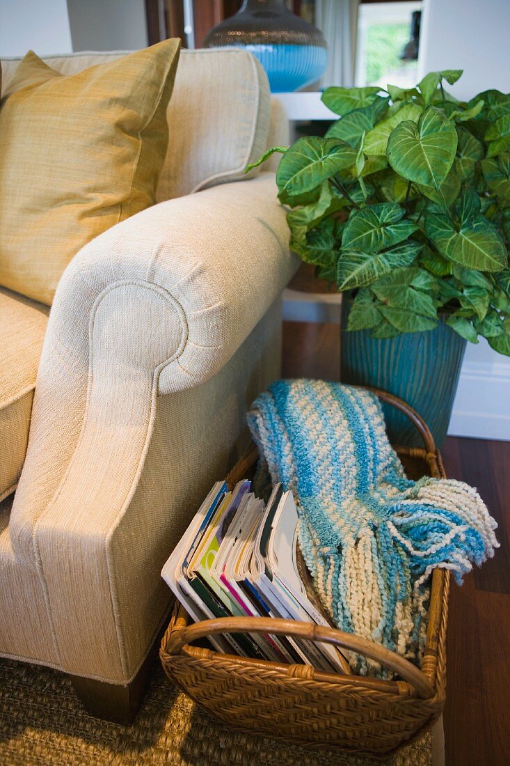 Basket of magazines next to armchair