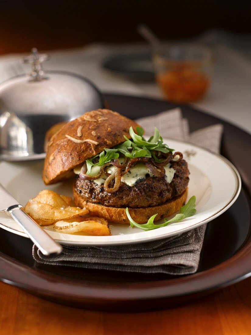 Hamburger mit Rucola, Zwiebeln, Blauschimmelkäse und Kartoffelchips