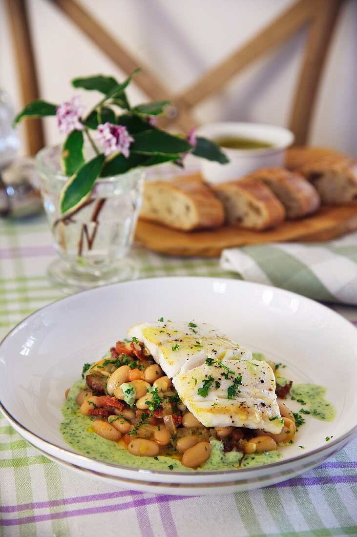 Cod on a bean medley with chorizo and green sauce