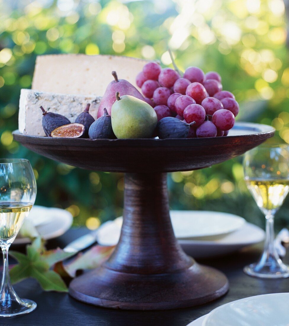 Organic Fall Fruit and Cheese on a Pedestal Dish on an Outdoor Table