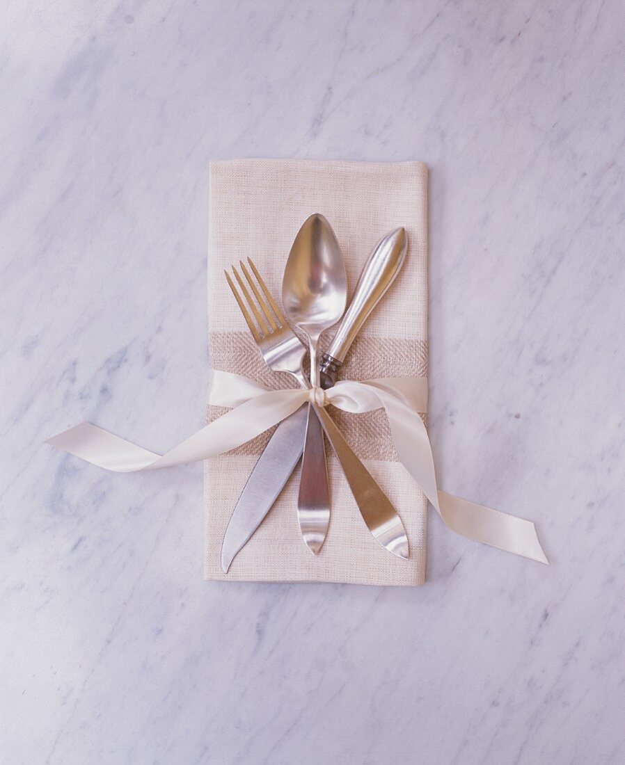 Elegant Place Setting with Fork, Knife and Spoon Tied to a Cloth Napkin with a Ribbon
