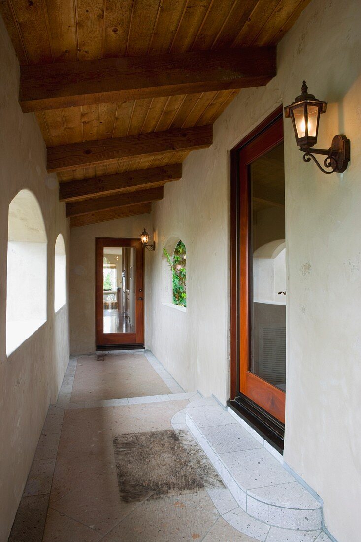 Vignette of hallway with wood door arches and lights.