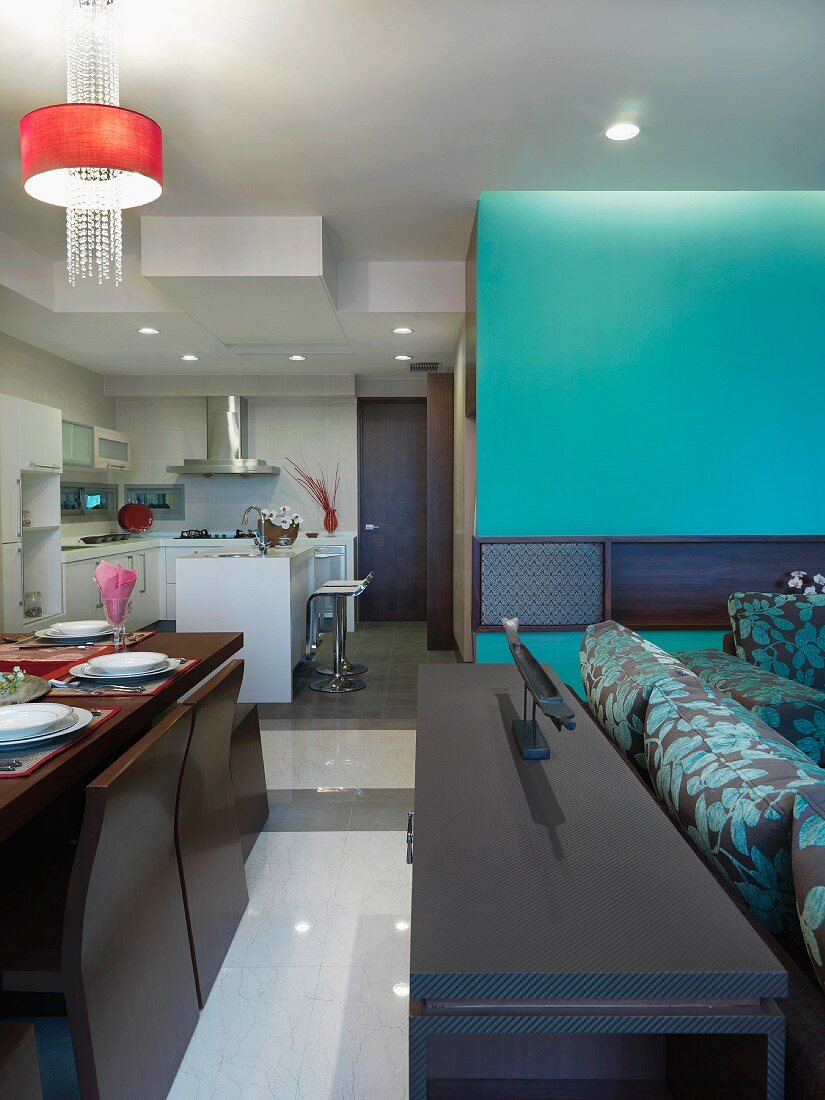 Modern living room dining room and kitchen with teal accents