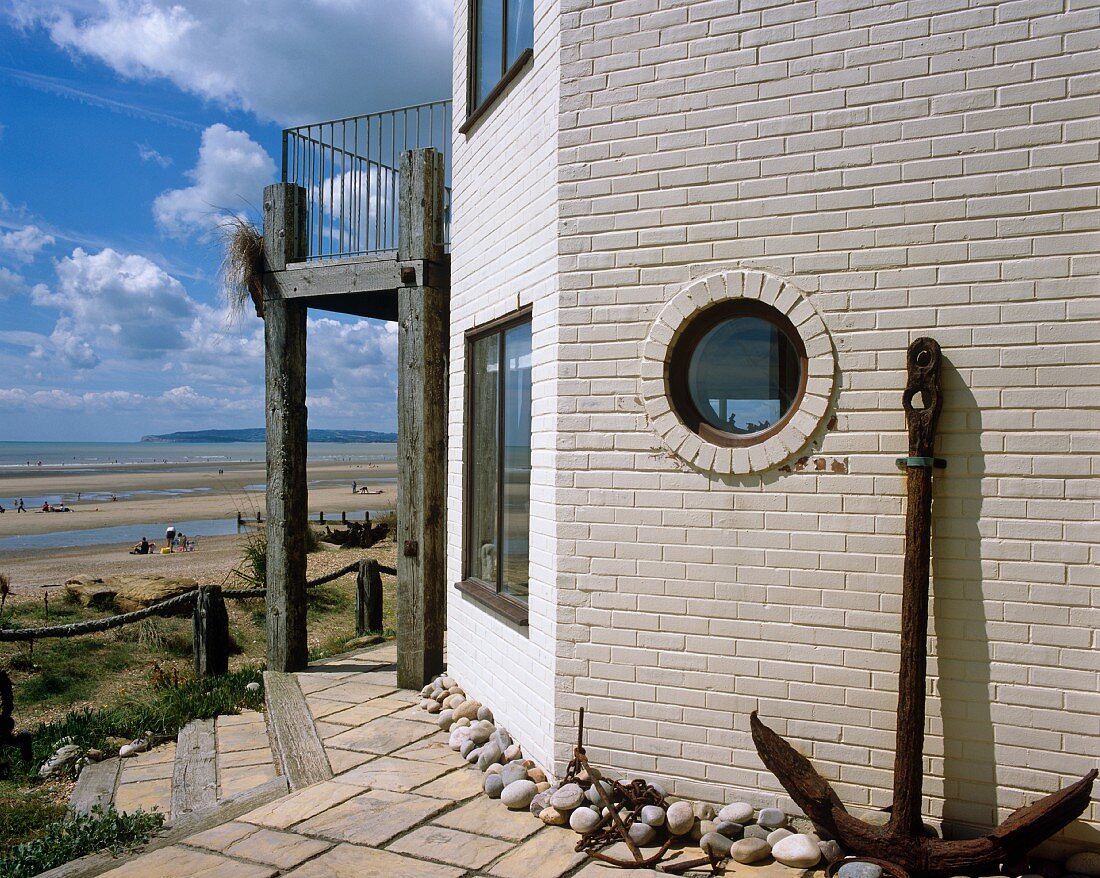 Contemporary house with whitewashed brick facade and view of sandy beach