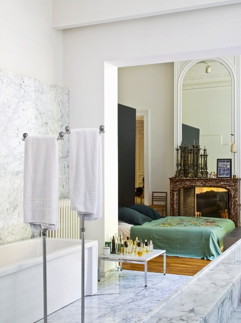 Marble bathroom with open doorway leading to bedroom