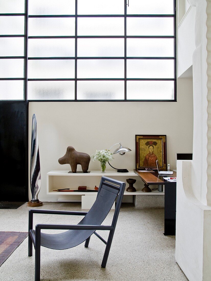 Designer-Stuhl vor Ablage in einer loftartigen Wohnung
