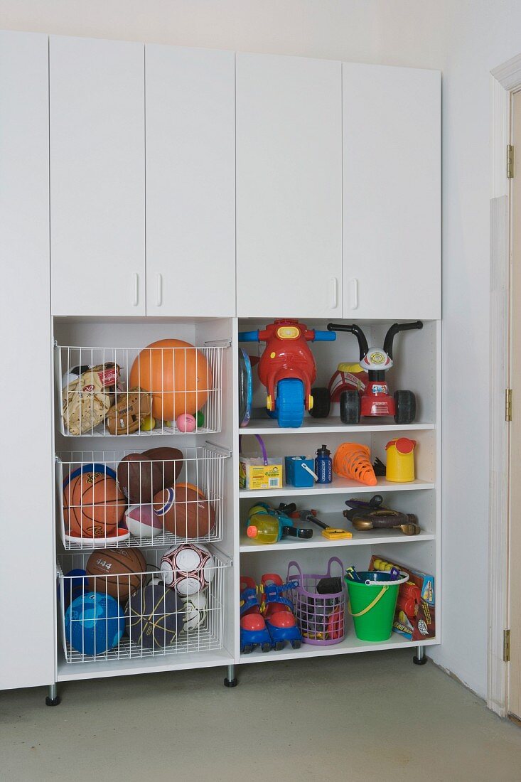 Fitted cupboards and shelves holding toys and sports equipment