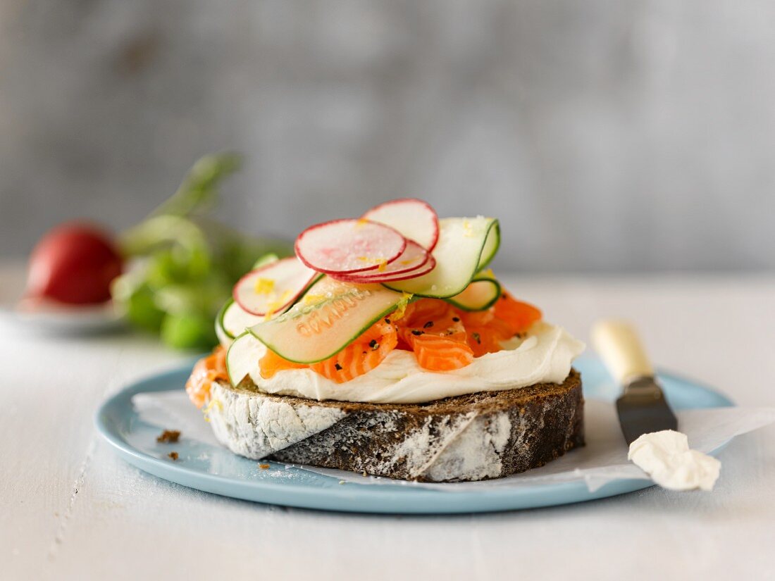 Belegtes Brot mit Frischkäse, Räucherlachs, Gurken und Radieschen