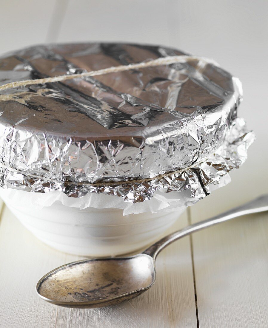 A pudding basin covered with aluminium foil