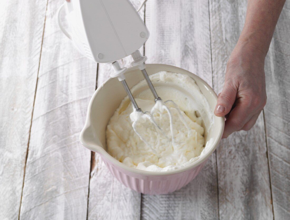 Cream being whipped with a hand whisk