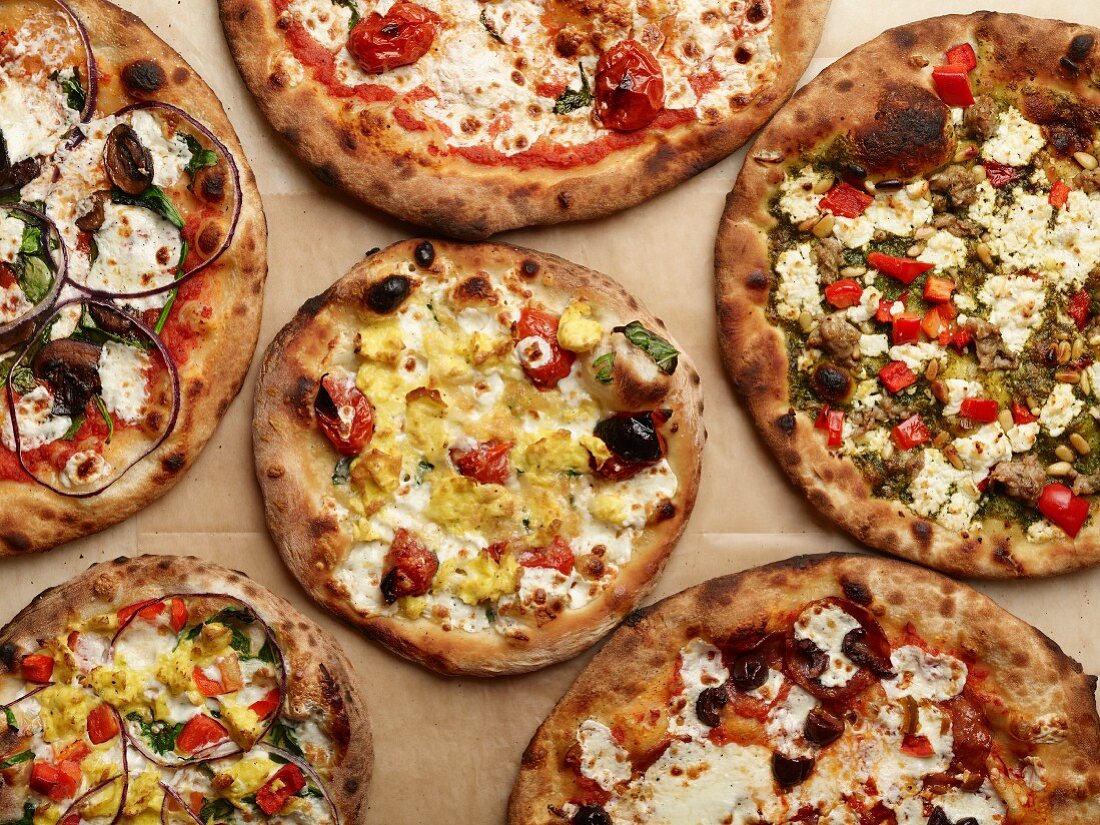 Pizzas with various toppings (seen from above)