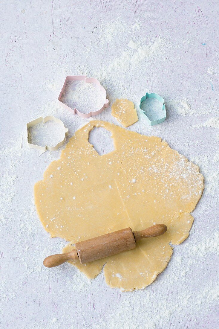 Rolled out shortcrust pastry with baking utensils for making children's biscuits