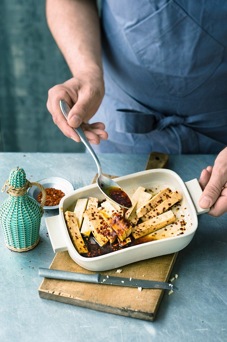 Tofu in Sojasauce und Chiliflocken marinieren