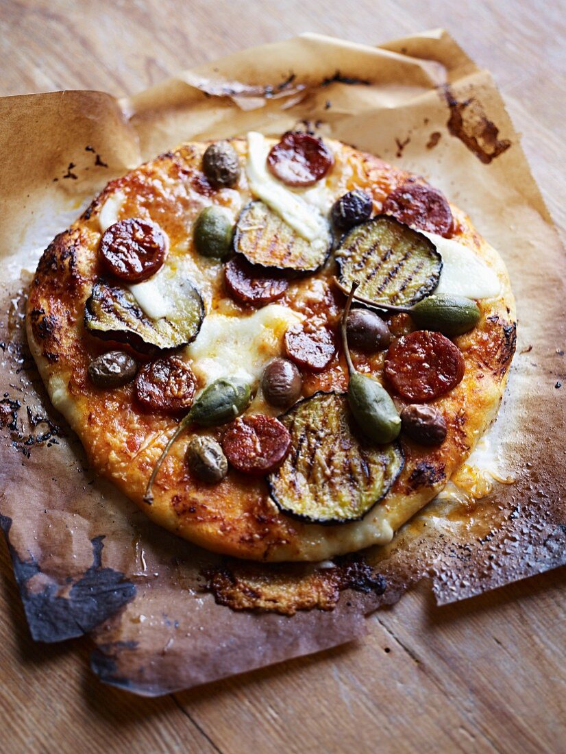 Pizza with grilled vegetables, capers and salami