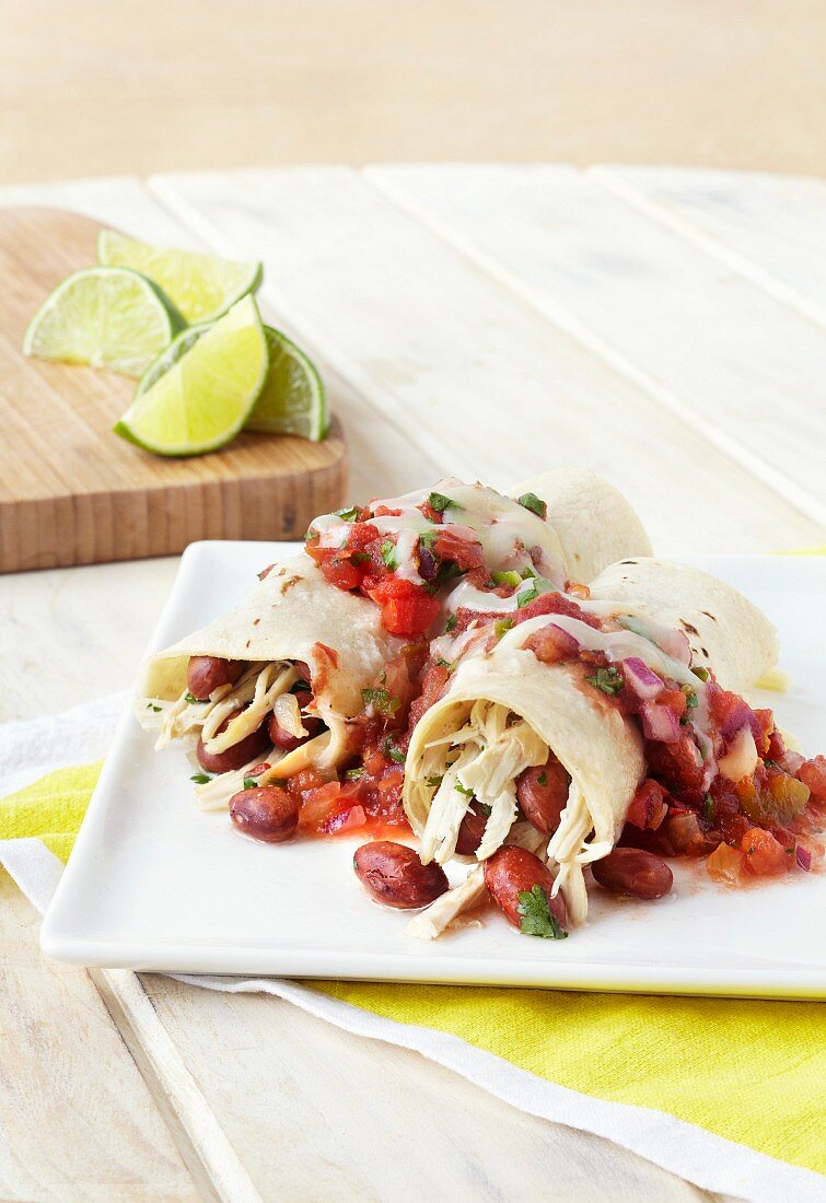 Hähnchen-Enchiladas mit Bohnen und Salsa auf einem Teller