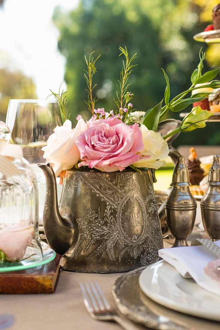Roses in teapot decorating tea-time buffet