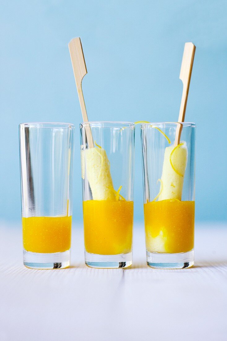 Elderflower and lemon sorbet on sticks with mango and elderflower and jus in glasses