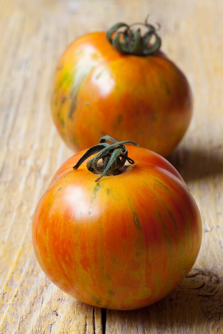 Two tomatoes on a wooden table