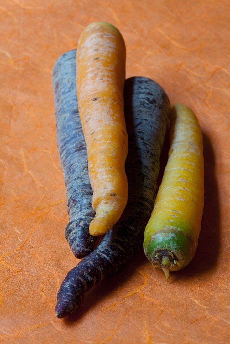 Coloured carrots on orange paper