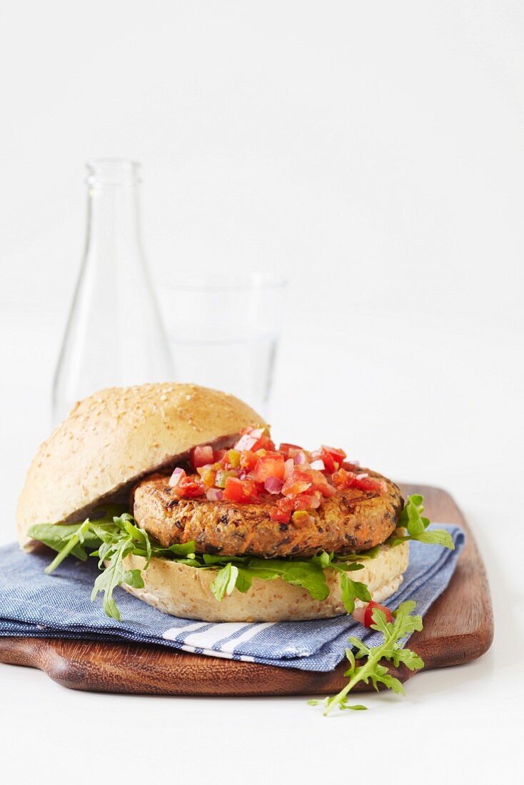 A grilled vegetarian burger on a wholemeal bun with tomato salsa