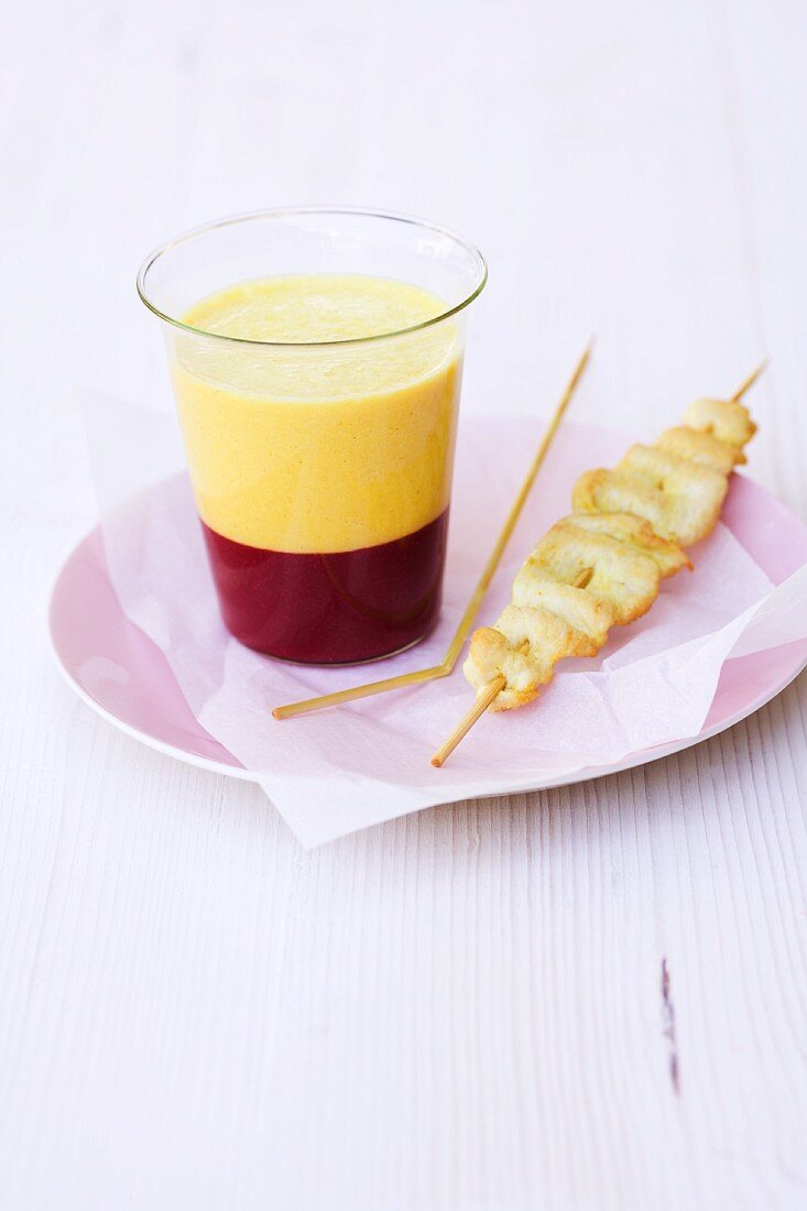 Yellow pepper soup with raspberry jelly and a corn-fed chicken satay skewer