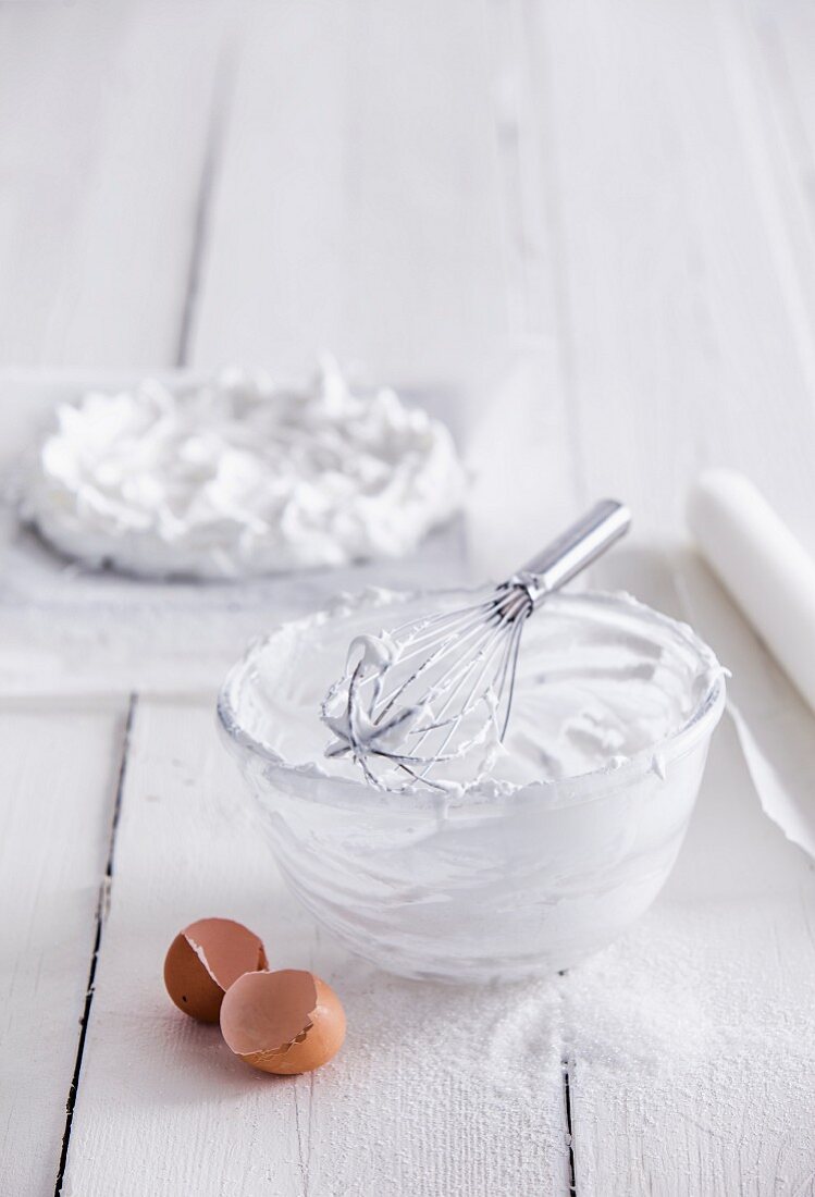 The remains of beaten egg white in a bowl with a whisk