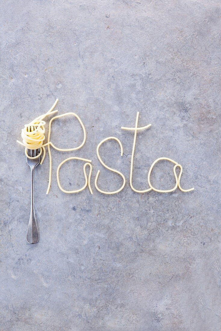 The word 'pasta' written in spaghetti with a fork