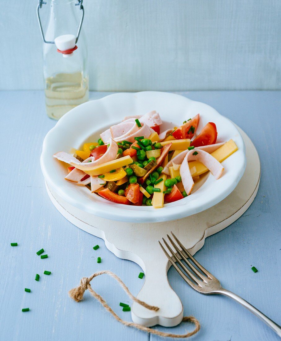 A colourful cheese and ham salad with peas