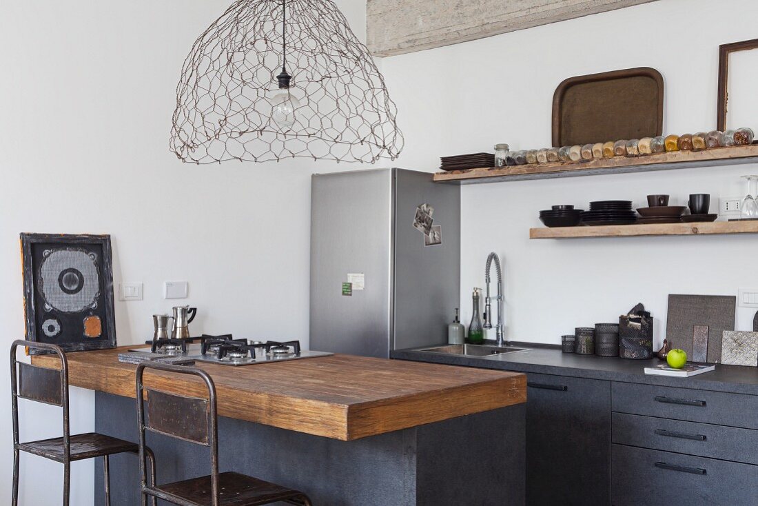 Kitchen counter with gas stove top in a kitchen corner with stainless steel refrigerator