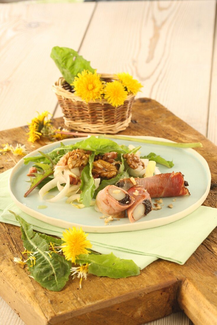 Spring salad with nuts, dandelion leaves, wild garlic, ham rolls and chicory