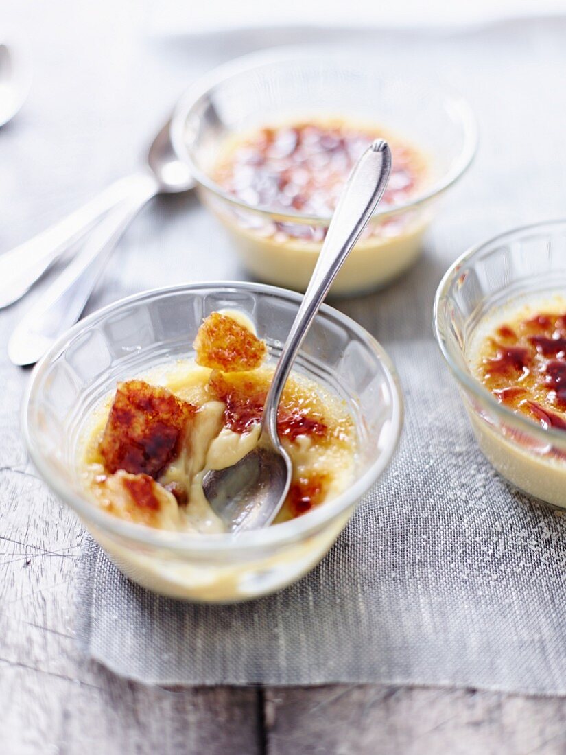 Crème brûlée, halb aufgegessen, in Glasschälchen